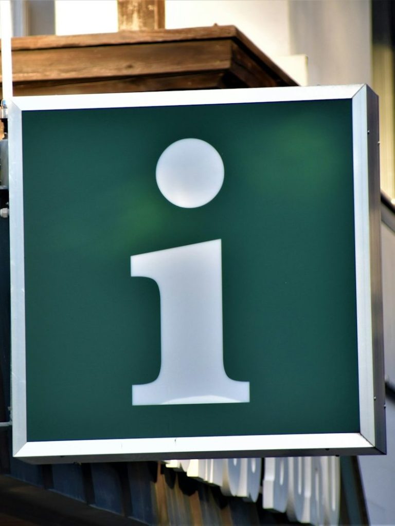 Grünes Informationsschild mit einem weißen „i“ darauf.