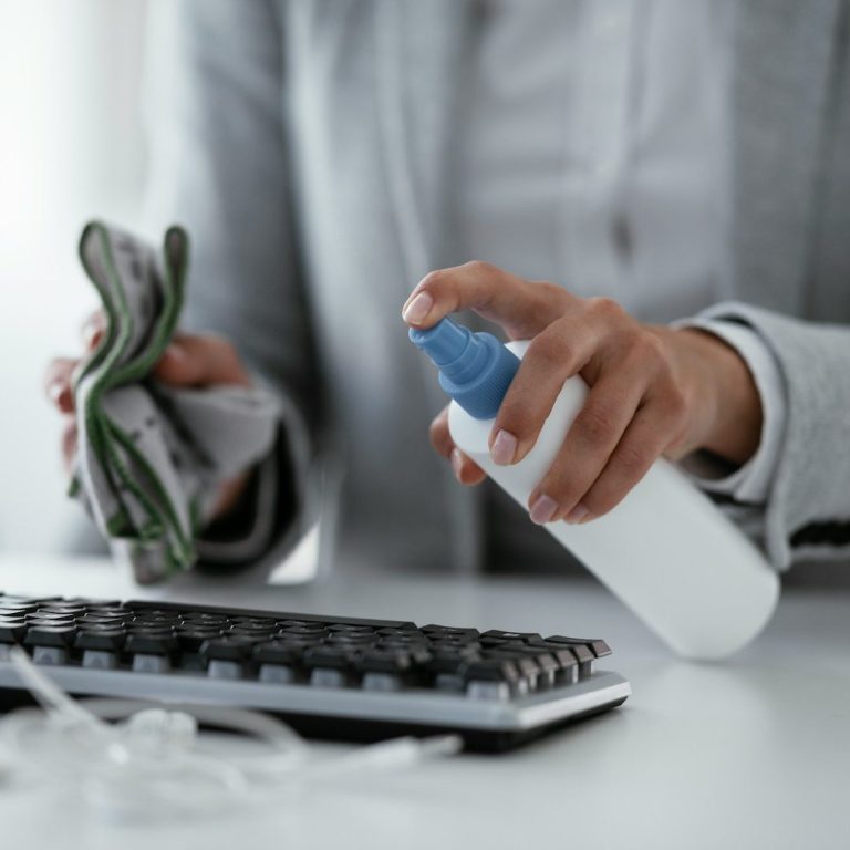 Eine Person reinigt eine Computer-Tastatur mit einem Spray und einem Tuch.
Einfache Desinfektionsreinigung